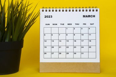 Mart 2023 sarı arka planda masa örtüsü olan masa takvimi. Takvim kavramı