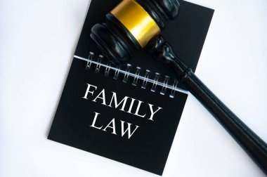 Top view of family law text on black notepad with gavel on white background. Law concept.
