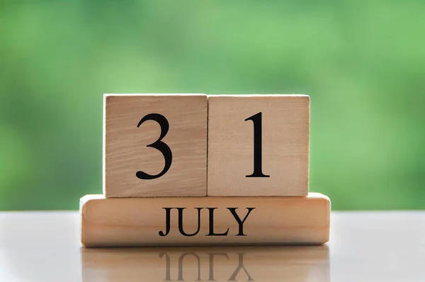 July 31 calendar date text on wooden blocks with blurred background park. Copy space and calendar concept