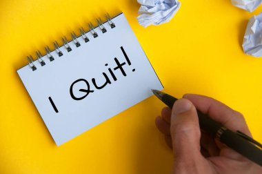I quit text on white notepad on yellow cover background. Employment and resignation
