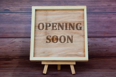 Opening soon text engraved on wooden frame. Business opening concept.
