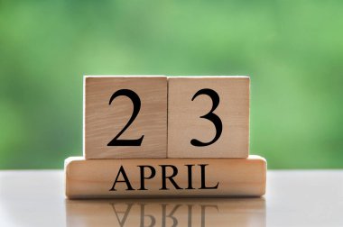 April 23 calendar date text on wooden blocks with blurred park background. Copy space and calendar concept.