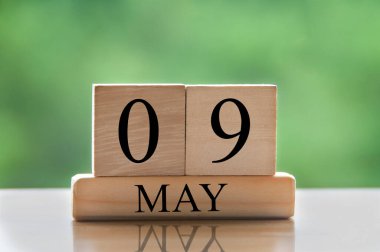 May 9 calendar date text on wooden blocks with blurred nature background. Copy space and calendar concept.