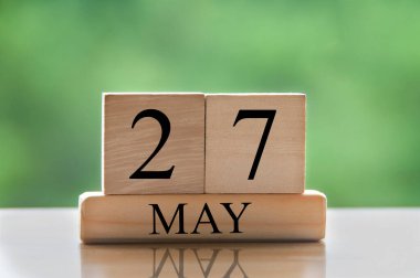 May 27 calendar date text on wooden blocks with blurred nature background. Copy space and calendar concept.