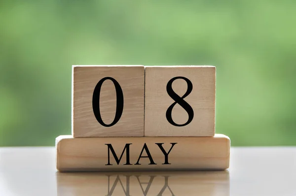 May 8 calendar date text on wooden blocks with blurred nature background. Copy space and calendar concept.