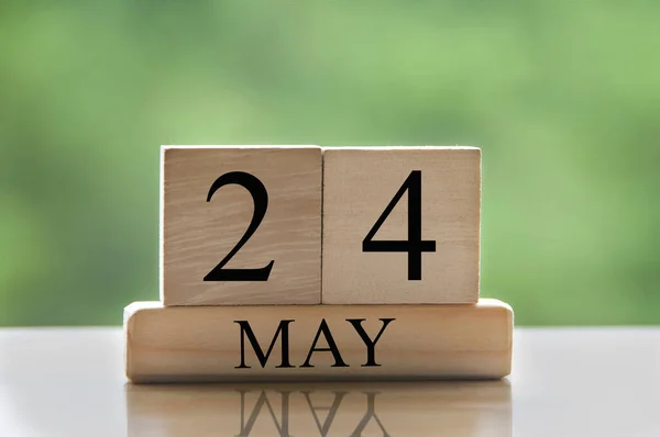 May 24 calendar date text on wooden blocks with blurred nature background. Copy space and calendar concept.