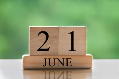June 21 calendar date text on wooden blocks with blurred nature background. Copy space and calendar concept.
