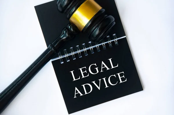 Legal advice text on black notepad with gavel on white background. Legal and law concept.