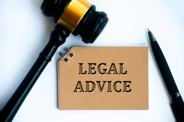 Legal advice text on brown notepad with gavel and pen on white background. Legal and law concept.