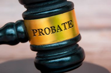 Probate text engraved on gavel with blurred wooden cover background. Legal and law concept.