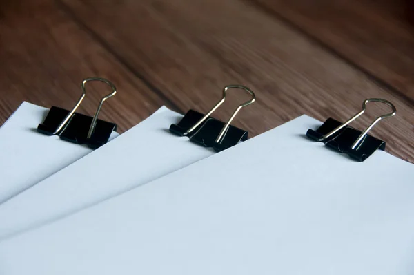 Paper stack of clipped pile of documents on wooden desk. Copy space and business offices concept.