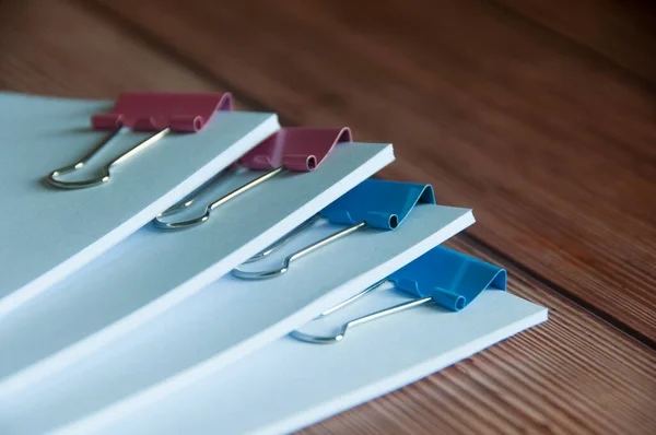 Paper stack of clipped pile of documents on wooden desk. Copy space and business offices concept.