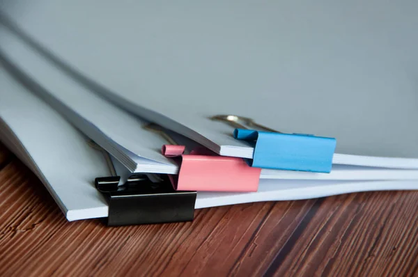 Paper stack of pile of documents on wooden desk. Copy space and business offices concept.