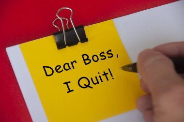 Dear boss, I quit text on yellow notepad on red cover background. Employment and resignation concept.