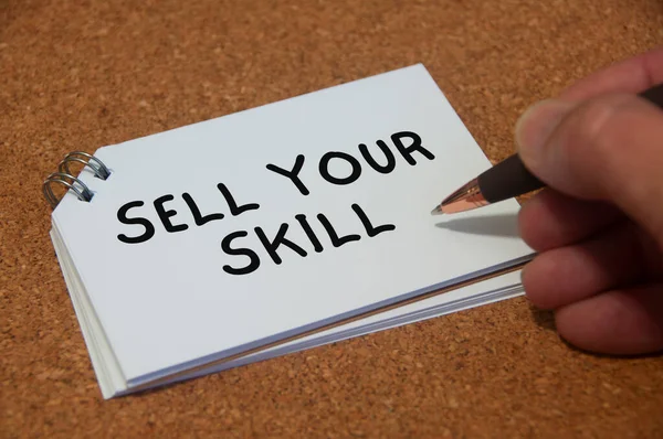 Hand writing sell your skill text on white notepad. Skill concept.