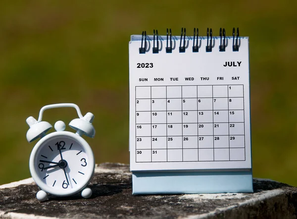 July 2023 White Desk Calendar Alarm Clock Glass Rock Background — Stock Photo, Image