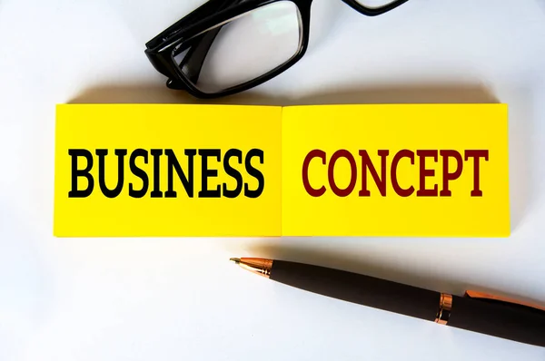 黄色のノートパッドのビジネスコンセプトテキストガラスと白の背景にペンで 事業概念 — ストック写真