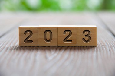 Ahşap bloklara oyulmuş, bulanık park geçmişi olan 2023 yazı. Yeni yıl kavramı.