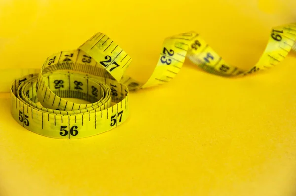 Measuring tapes on yellow cover background with customizable space for