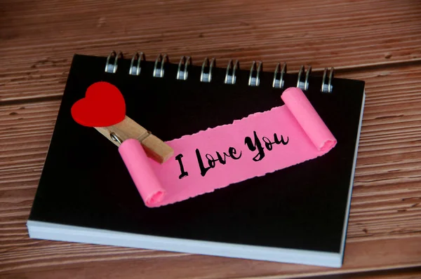 I love you text on torn pink paper. Romance and relationship concept.
