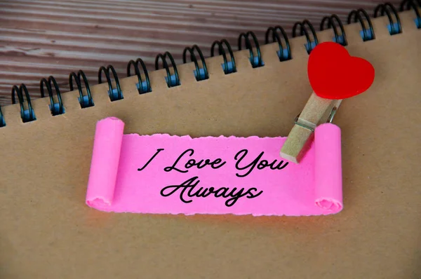 I love you text on torn pink paper. Romance and relationship concept.
