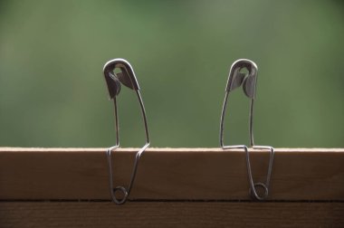 Güvenlik iğnesi çifti masada oturup birbirlerini görmezden geliyor. Çatışma ve romantizm kavramı.
