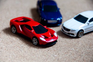 Kuala Lumpur, Malezya - Eylül 2022: Ford GT 'nin minyatür oyuncak arabasının seçici odak noktası ahşap kapaklı Mercedes AMG ve Bentley Continental GT. Boşluğu kopyala.