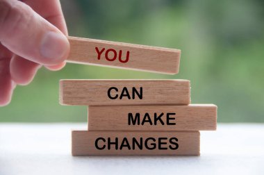 Tahta bloğu elle dizerek Değişiklik Yapabilirsin yazısıyla. İlham verici bir kavram.