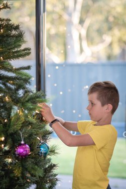 Güney Avustralya 'da Noel ağacı süsleyen bir çocuğun portresi.