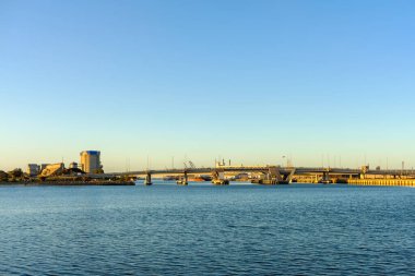 Port Adelaide 'in sanayi bölgesi, Güney Avustralya' da gün batımında Port Nehri üzerindeki köprüyle birlikte.