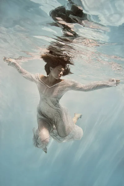 Dziewczyna Niebieskiej Sukience Pływa Pod Wodą Jasnym Tle Jakby Była — Zdjęcie stockowe