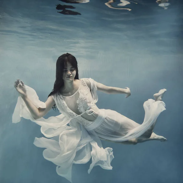 머리를 소녀는 무중력 상태에서 하늘을 것처럼 물속을 수영한다 — 스톡 사진