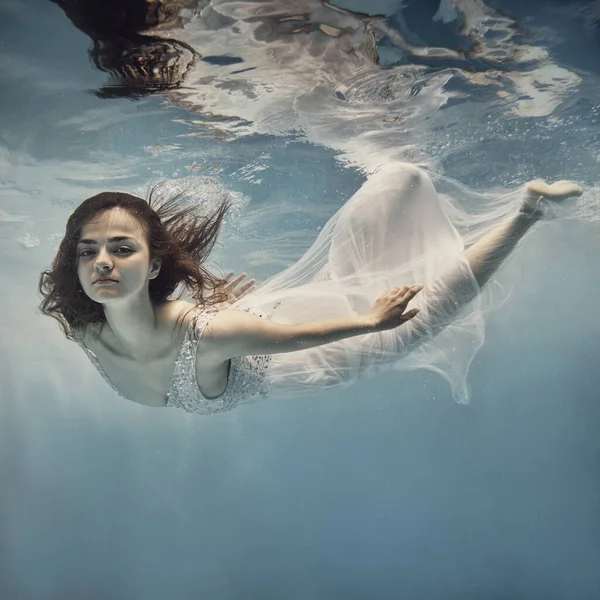 드레스를 머리를 여자가 하늘을 것처럼 물속을 수영한다 — 스톡 사진