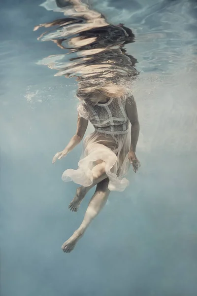 드레스를 여자는 무중력 상태에서 떠다니는 것처럼 물속을 헤엄친다 — 스톡 사진