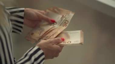 Kadınların para saydığı yakın plan çekimler. 50 Euro.