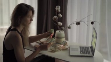 Yetişkin bir kadın euro banknotlarını sayıyor. Aile bütçesi. Not defterine, laptopa yazıyorum. Avro saymak, para saymak.