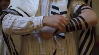 Yetişkin bir erkek, bir Yahudi, tefillin sürüyor. El yakın çekim