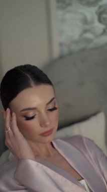 Dikey klip, portre. Avrupa görünümlü güzel genç bir kadın kamerayla oynar.