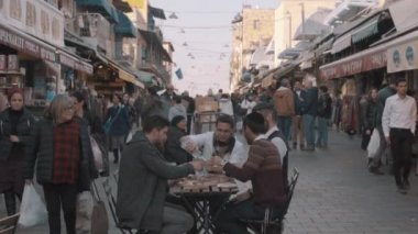 Kudüs, İsrail - 14 Şubat 2022: Genç Yahudiler Kudüs 'teki Mahane Yehuda pazarının ortasında, Purim bayramını kutluyorlar. Kamera uzaklaşıyor.