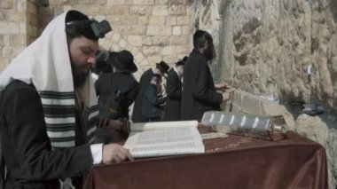 Jerusalem, Israel - February 14, 2022: Western Wall Square. Jewish people pray near the Great Wailing Wall. Side view in profile