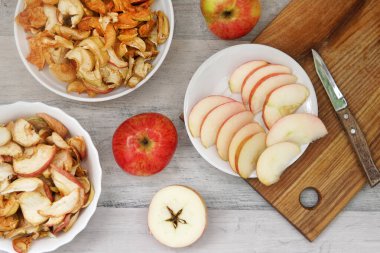 üç elma ve üç tabak kuru elma ve masada elmalar ve bıçak.