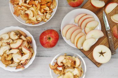 Üç elma ve üç tabak kuru elma ve bıçaklı elmalar.