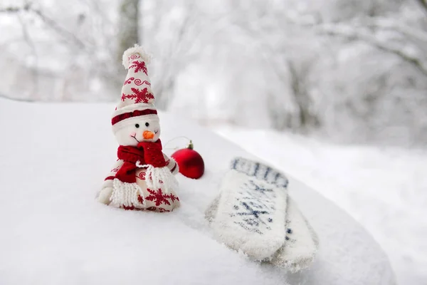 Manoplas muñeco de nieve bola roja en una deriva de nieve en invierno en el bosque —  Fotos de Stock