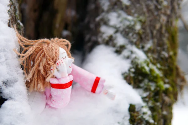 Duerme. juguete chica ángel duerme en un árbol en la nieve —  Fotos de Stock