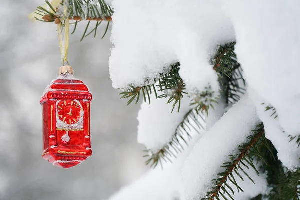 Reloj de juguete rojo en el árbol de Navidad en invierno en el bosque —  Fotos de Stock