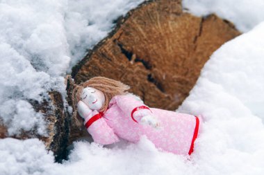 Ormanda uyuyan bir melek. Karda bir oyuncak.