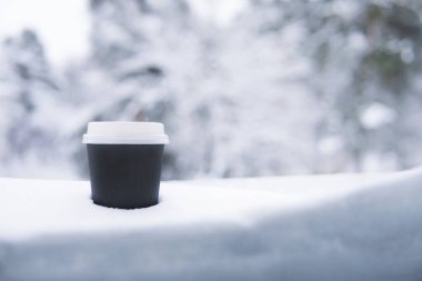 Kışın karda siyah bir kağıt bardak. - Kahve. Boşluğu kopyala
