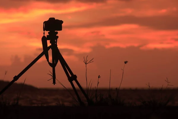üç ayaklı fotoğraf makinesi Gün batımında, alacakaranlıkta, bulutların renkleri ve şekillerinde