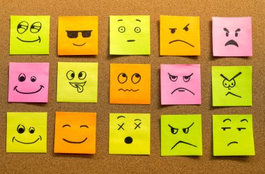 Kendine yapıştırıcı ofis notları ve mantar panoda farklı yüz ifadeleri soyut konsept fotoğraf olarak