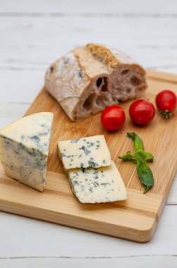 Tahtada mavi peynir, domates ve fesleğen.